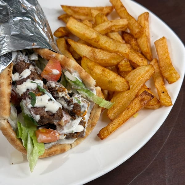 Ruz Bukhari's Afghan gyro with meat, lettuce, tomatoes, and white sauce, served with golden fries.