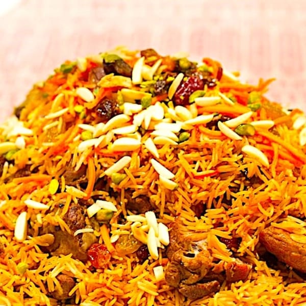 Close-up of Ruz Bukhari's Afghan rice pilaf with meat, carrots, raisins, almonds, and pistachios.